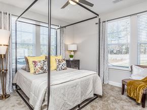 Raleigh apartment for rent - a bedroom with a bed and a ceiling fan