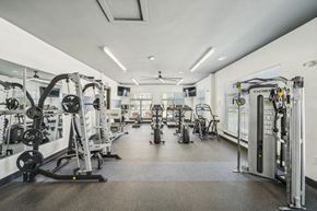 Fuquay-Varina apartment for rent - a gym with weights and cardio machines and a ceiling fan