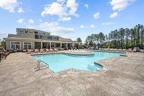Fuquay-Varina apartment for rent - a resort style pool with lounge chairs and a building in the background