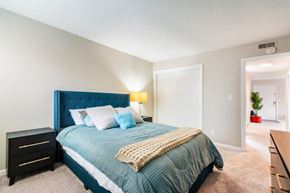 Greensboro apartment for rent - A bedroom with a blue headboard and a bed with a green comforter.
