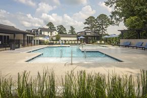 Greenville apartment for rent - A large outdoor swimming pool surrounded by grass.