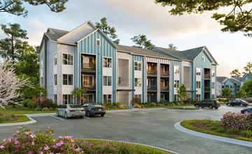 Hampstead apartment for rent - A large building with a parking lot in front of it.