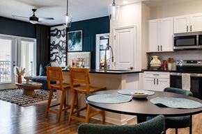 Belville apartment for rent - A kitchen with a table and chairs in front of it. at Evolve Waterford Apartments in Belville, NC