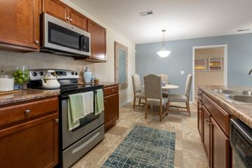 Fayetteville apartment for rent - full kitchen with stainless steel appliances and a dining room with a table and chairs