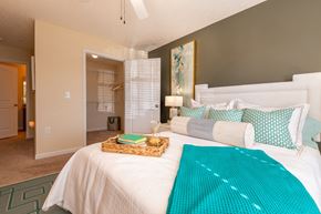 Fayetteville apartment for rent - a bedroom with a white bed and a blue blanket