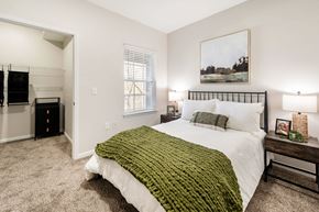 Knoxville apartment for rent - A bedroom with a large bed and a painting on the wall.
