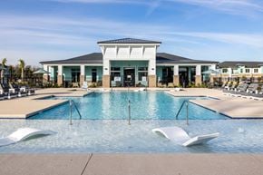 Myrtle Beach apartment for rent - a swimming pool with chairs and a building in the background