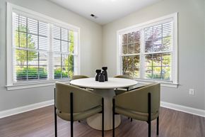 Durham apartment for rent - a dining room with two windows and a table and chairs