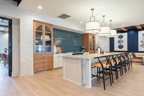 Leland apartment for rent - a large white kitchen with a long island and chairs