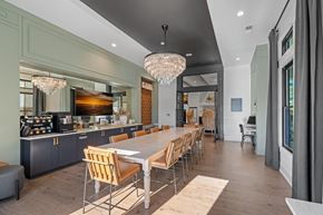 Wake Forest apartment for rent - A modern kitchen with a long dining table and multiple chairs for seating.