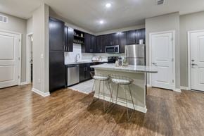 Jacksonville apartment for rent - A kitchen with black cabinets and a granite countertop.