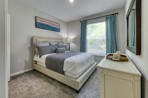 Palm Coast apartment for rent - A bedroom with a large bed and a painting on the wall.