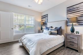 Columbia apartment for rent - A bedroom with a large bed, a dresser, and a ceiling fan.