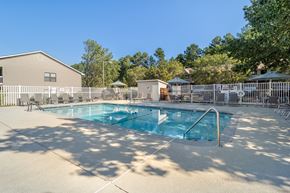 Spring Lake apartment for rent - our resort style pool is surrounded by a fence and trees