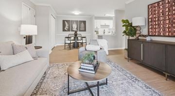 Knoxville apartment for rent - A living room with a white couch, a coffee table, and a large painting on the wall.