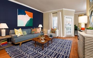 Durham apartment for rent - A living room with a blue couch and a painting on the wall.