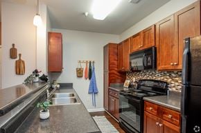 Holly Springs apartment for rent - A kitchen with wooden cabinets and black appliances.
