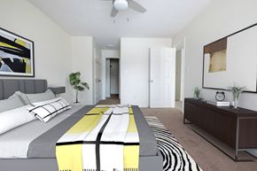 Raleigh apartment for rent - a bedroom with a large bed and a ceiling fan