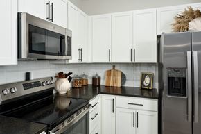 Southport apartment for rent - A kitchen with white cabinets and black countertops.
