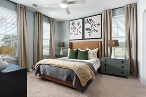 Southport apartment for rent - A bedroom with a large bed, a ceiling fan, and a painting on the wall.