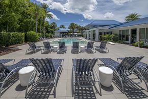 Jacksonville apartment for rent - A pool surrounded by black chairs and tables.
