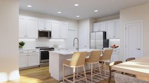 Calabash apartment for rent - a large kitchen with white cabinets and a island with chairs