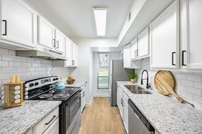 Greensboro apartment for rent - a kitchen with white cabinets and a stove and a sink