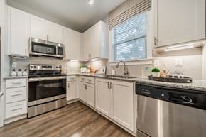 Apex apartment for rent - a kitchen with stainless steel appliances and white cabinets