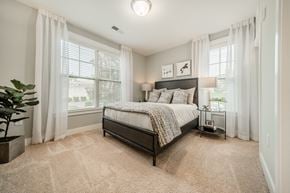 Apex apartment for rent - a bedroom with a bed and two windows