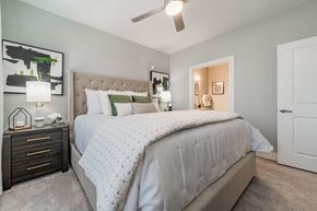 Wake Forest apartment for rent - a bedroom with a large bed and a ceiling fan