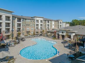 Wake Forest apartment for rent - a swimming pool with an apartment building in the background
