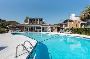 Charleston apartment for rent - A large swimming pool with a diving board and lounge chairs.