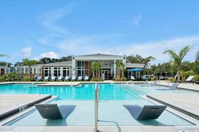 Wildwood apartment for rent - A pool with a building behind it.