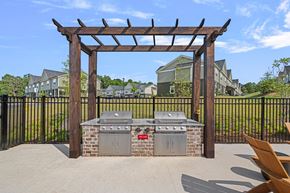 Weaverville townhouse for rent - A BBQ grill is under a wooden pergola in a backyard.
