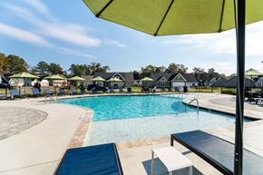 Hixson apartment for rent - A pool with a green umbrella in the foreground.