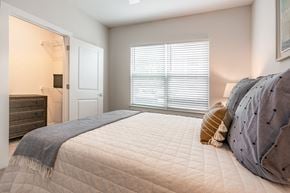Greensboro apartment for rent - a bedroom with a large bed and a door to a bathroom