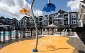 Fuquay-Varina apartment for rent - a water playground in front of a pool with apartments in the background