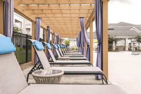 Pooler apartment for rent - a row of lounge chairs on the porch of a building