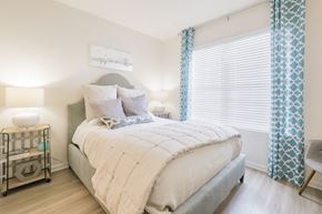 Pooler apartment for rent - a bedroom with a bed and a window with blue curtains