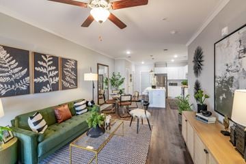 Hope Mills apartment for rent - A living room with a green couch and a chandelier.