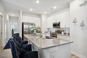 Longs apartment for rent - A white kitchen with a granite counter top and white cabinets at 15 at Heron Apartments in Longs, SC.