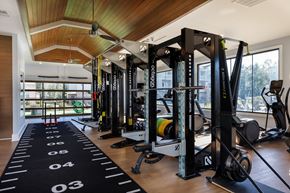 Fayetteville apartment for rent - A gym with a row of squat racks and a black mat with numbers on it.