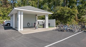 Myrtle Beach apartment for rent - A small white building with a grey roof is surrounded by a parking lot with bicycles parked in front.