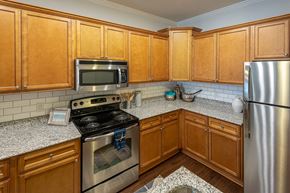 Fayetteville apartment for rent - a kitchen with stainless steel appliances and wooden cabinets