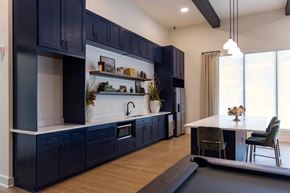 Hendersonville apartment for rent - Modern Clubhouse kitchen with dark blue cabinets and a white countertop.