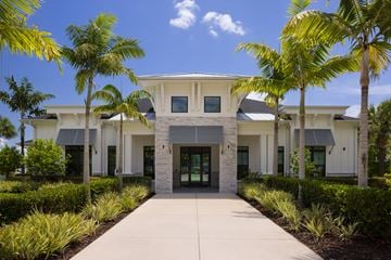 Cape Coral apartment for rent - A white building with a grey roof and a walkway in front.