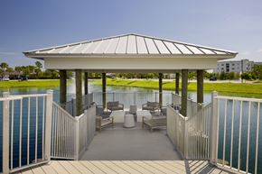 Cape Coral apartment for rent - A gazebo with a white roof is surrounded by a white fence and has a deck with chairs and a table.