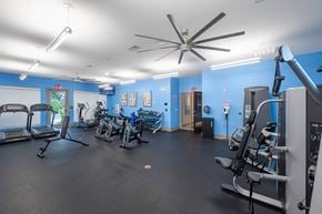 Jacksonville apartment for rent - a gym with exercise equipment and a ceiling fan