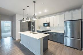 Greensboro apartment for rent - A modern kitchen with a white island and stainless steel appliances.