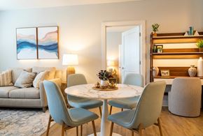 Morehead City apartment for rent - A modern dining room with a round marble table and grey chairs.